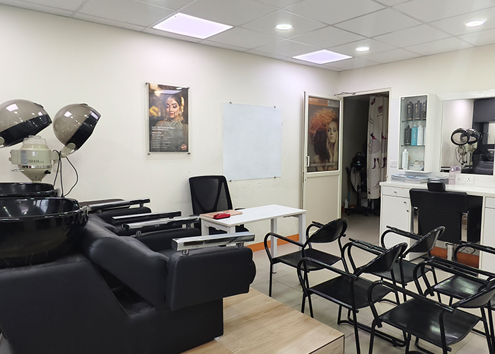 Beauty training classroom at VLCC School of Beauty Chromepet with instructional
                     chairs and mirrors.