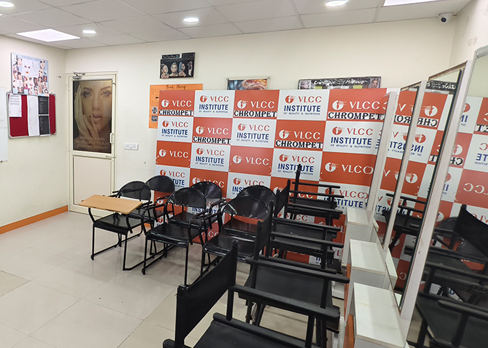 Classroom setup at VLCC School of Beauty Chromepet with chairs, mirrors, and a makeup
                     ring light.