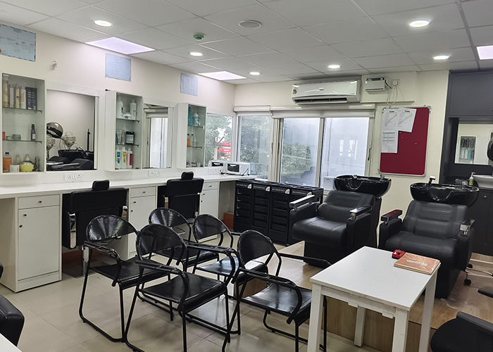 Hair styling and salon setup at VLCC School of Beauty Chromepet with styling chairs
                     and wash stations.